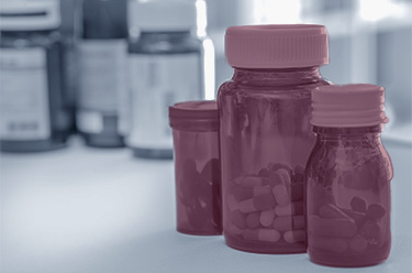 several pharmaceutical containers of different sizes are filled with tablets and placed on a table