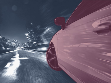 Side view of a car travelling on a wet road 